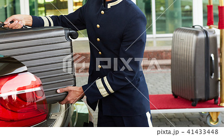 Bellboy taking baggage of guest from thee car to his room 41433448