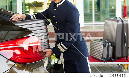 Bellboy taking baggage of guest from thee car to his room 41433456
