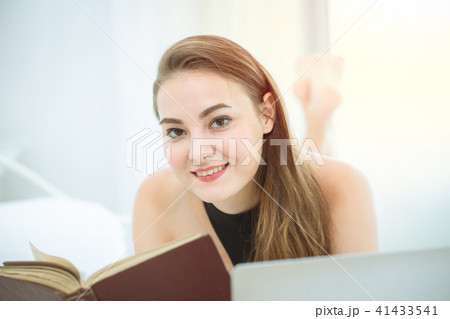 beautiful woman reading a book and smile lie 41433541
