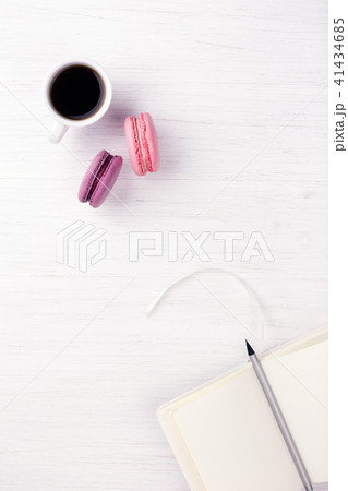 A cup of coffee and macarons on the table. 41434685