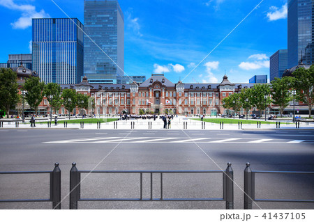 若葉と新緑の東京駅丸の内駅前広場と青空の写真素材