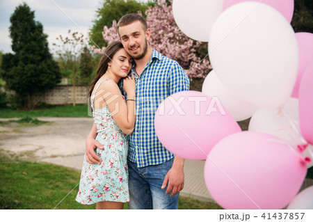 Young happy couple in love outdoors. Handsome man and beautiful woman on a walk in a spring blooming 41437857