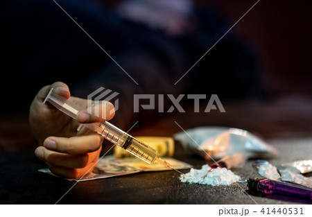 Male junkie hand holding heroin drug syringe 41440531