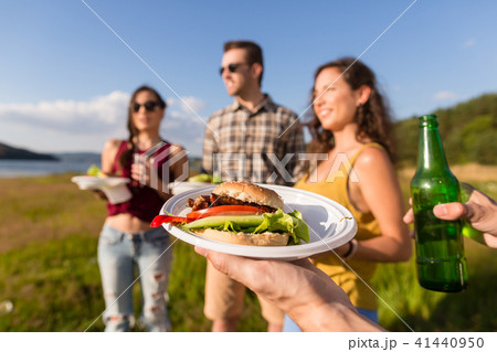 Young people on barbecue party, burger and beer Young people on barbecue party, burger and beer 41440950