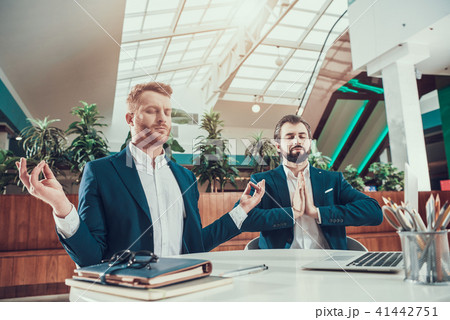 Two worker men meditating at desk in office. Two worker men meditating at desk in office. 41442751