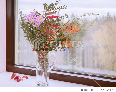 Bouquet of autumn flowers and leaves on the windowsill. Bouquet of autumn flowers and leaves on the windowsill. 41443747