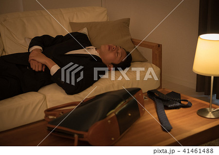 帰宅してソファで寝てしまう若いビジネスマン 41461488