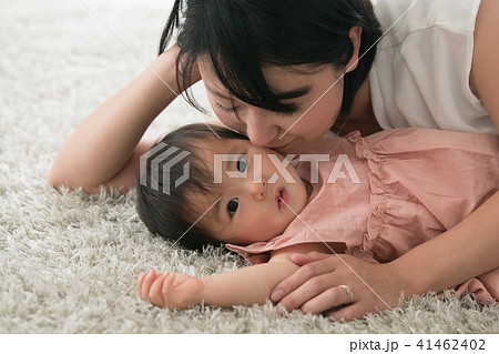 赤ちゃんにキスする若い母親の写真素材