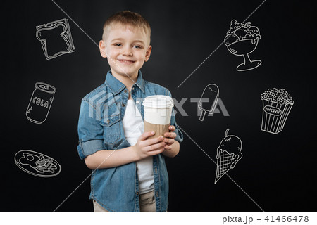 Adorable child smiling and buying tasty coffee for his loving mother Adorable child smiling and buying tasty coffee for his loving mother 41466478
