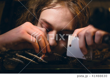 Close-up of the hands of an addicted young man snorting powdered substance Close-up of the hands of an addicted young man snorting powdered substance 41466630