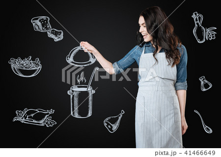 Excited housewife looking at the tasty soup while cooking it 41466649