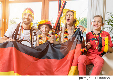 Whole family cheering for the German soccer team in front of TV 41466659