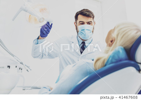 Delighted dentist treating his patient Delighted dentist treating his patient 41467608