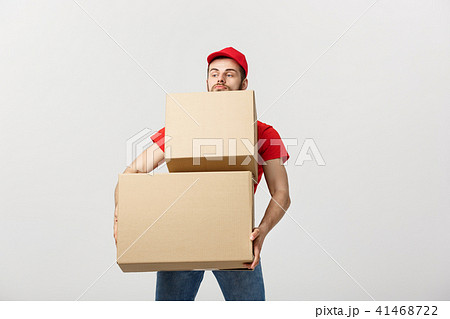 Delivery Concept: Man hardly carries the cardboard boxes, isolated on white background. Concept of 41468722