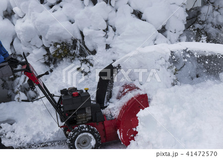 Red snowblower removing snow 41472570