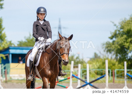 Young girl riding horse on equestrian competition 41474559