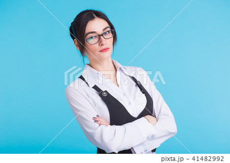 A pretty teenage brunette girl with glasses on blue background 41482992
