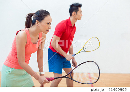 Competitive Chinese woman holding the racquet during a squash game 41490996