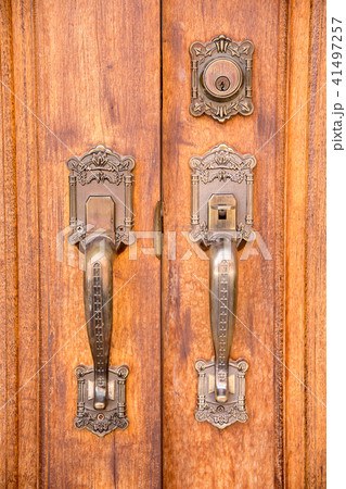 Vintage brass door handle with lock on wooden door 41497257