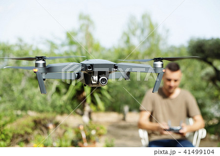 man operating a drone in a natural landscape. 41499104