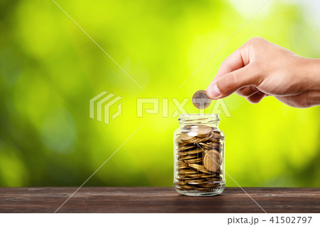 hand put money coins to glass jar 41502797