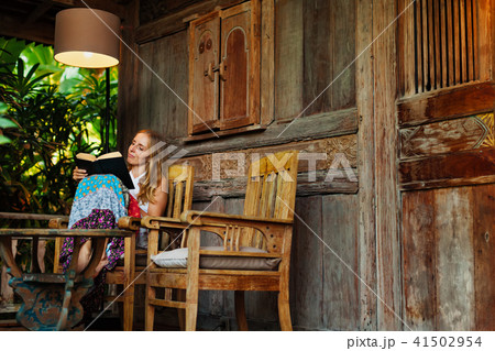 Young woman read paper book on outside veranda 41502954