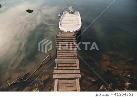boat is on the river near the wooden bridge boat is on the river near the wooden bridge 41504553