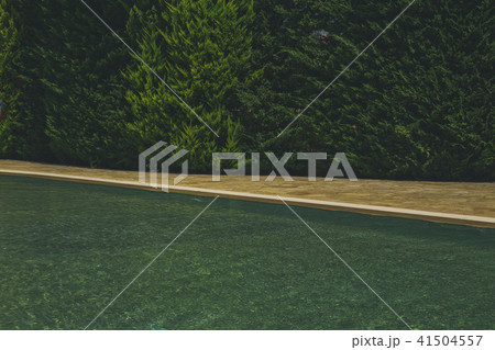 blue water in the pool on the background of a wooden floor with green tree 41504557
