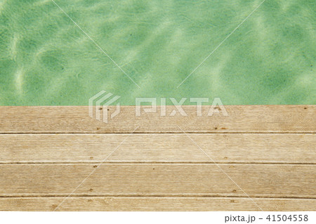 blue water in the pool on the background of a wooden floor with green tree 41504558