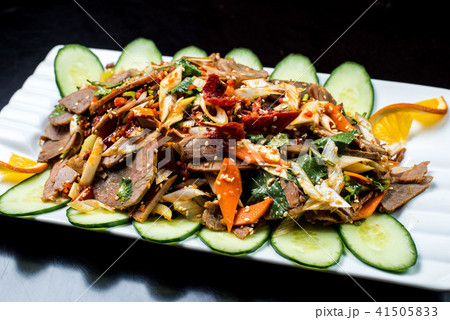 Chinese cuisine, boiled beef with cucumber and tomato in white plate, on black background 41505833