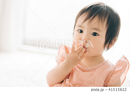 指しゃぶりをする赤ちゃん 女の子 1歳 子供の写真素材