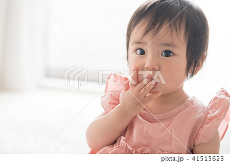指しゃぶりをする赤ちゃん 女の子 1歳 子供の写真素材