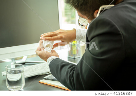 Businessman talking on cell phone and taking pills Businessman talking on cell phone and taking pills 41516837
