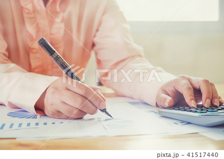 Asian Business woman using a calculator to count Asian Business woman using a calculator to count 41517440
