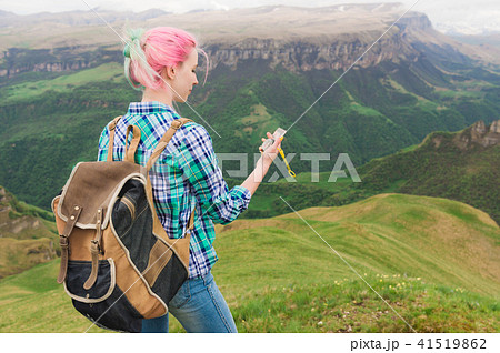 A hipster girl traveled with a blogger in a plaid shirt and with multi-colored hair using a compass 41519862