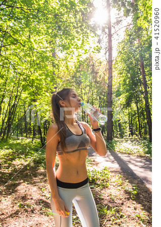 Young woman drinking water after running outdoors 41520960