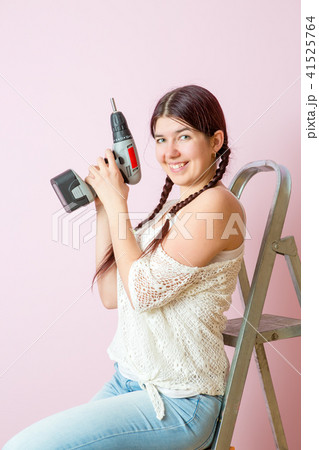 Photo of happy woman with drill near ladders 41525764
