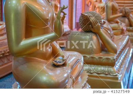 Donation coins lie on palm wax gilt figure monk. 41527549