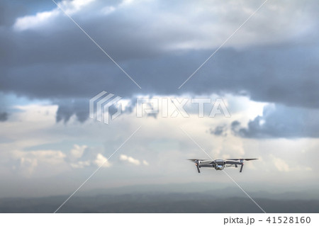 Drone quadrocopter with high resolution digital camera flying on the cloudy thunder sky Drone quadrocopter with high resolution digital camera flying on the cloudy thunder sky 41528160