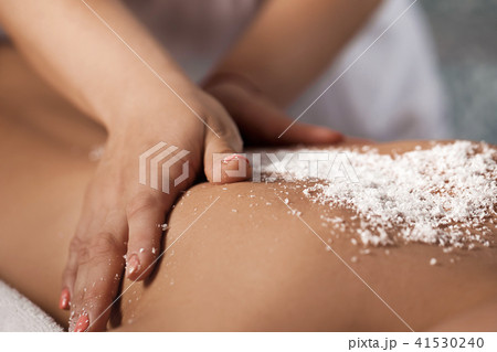 woman receiving massage with salt peeling woman receiving massage with salt peeling 41530240
