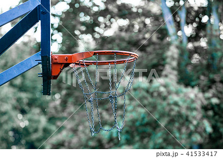 Picture of a basketball field goal with the trees in background. 41533417
