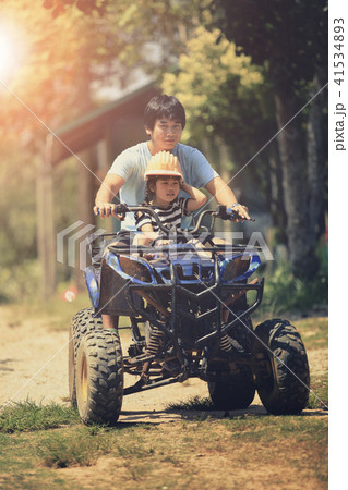 father and daughter riding on quad atv  41534893