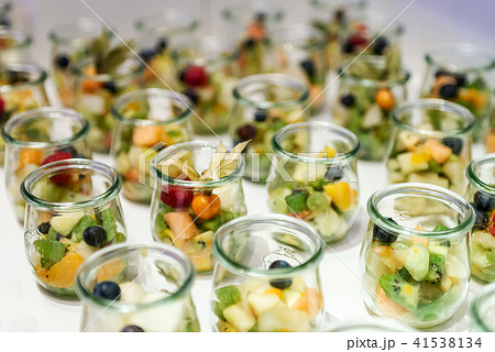 Closeup many dessert jar rowed up on buffet table with fresh fruits jelly and cream Closeup many dessert jar rowed up on buffet table with fresh fruits jelly and cream 41538134
