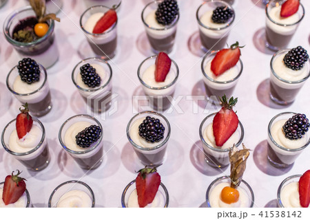 Closeup many dessert jar rowed up on buffet table with fresh fruits jelly and cream Closeup many dessert jar rowed up on buffet table with fresh fruits jelly and cream 41538142