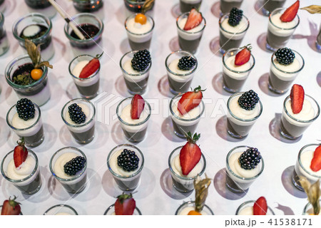 Closeup many dessert jar rowed up on buffet table with fresh fruits jelly and cream Closeup many dessert jar rowed up on buffet table with fresh fruits jelly and cream 41538171