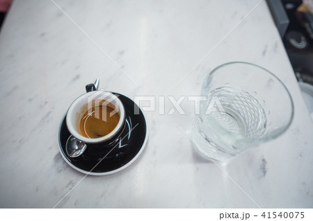 coffee mug and a glass of water on a table coffee mug and a glass of water on a table 41540075