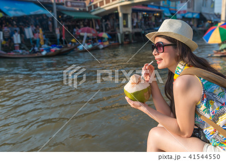 woman sit on the river bank drinkimg coconut juice 41544550