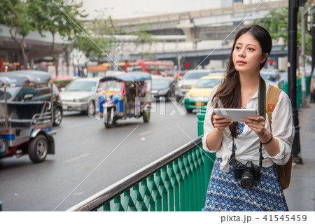 traveller using her touchpad beside the road traveller using her touchpad beside the road 41545459