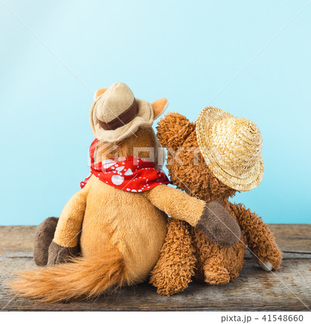 Friendship, teddy bear holding plush horse  41548660