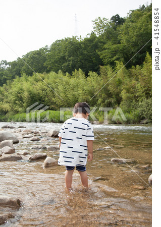 川遊びをする男の子の後ろ姿の写真素材